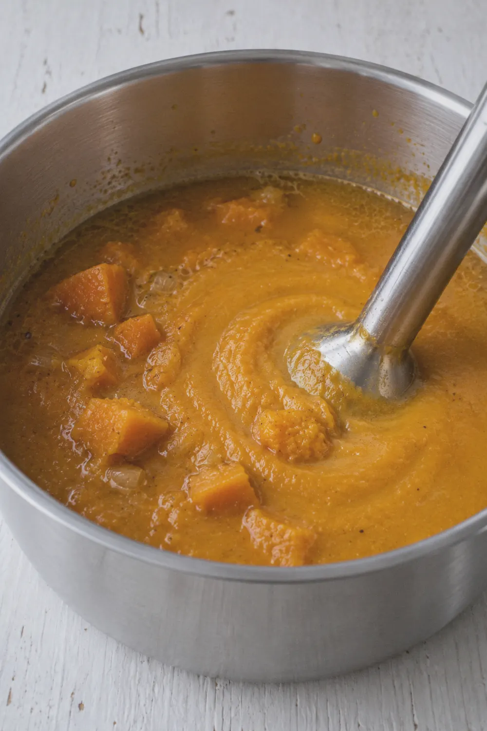 Blending butternut squash soup in the pot with an immersion blender