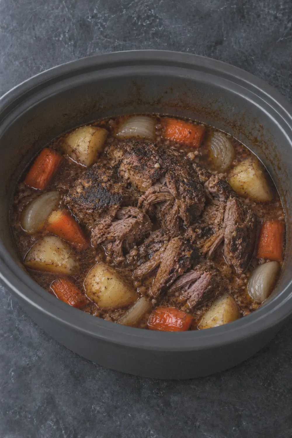 Finished pot roast in the slow cooker with tender vegetables