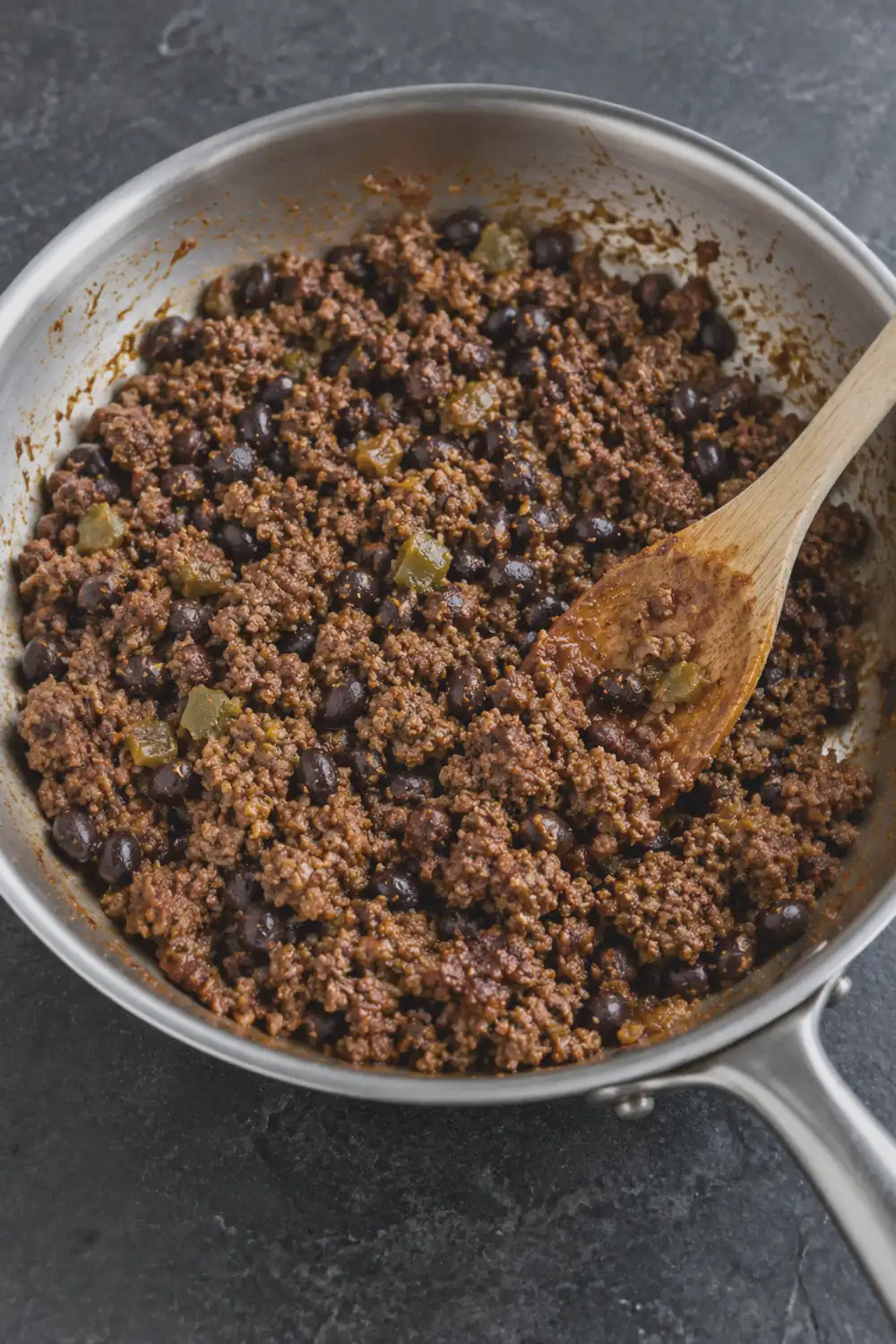 Seasoned ground beef with black beans and diced green chiles in a large skillet